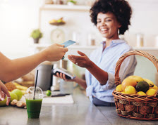 Business woman runs credit card at smoothie shop