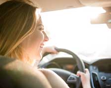 Woman smiles as she drives a new car