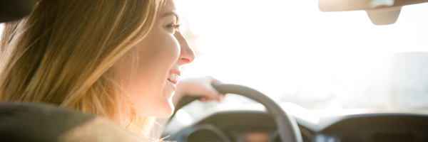 Woman smiles as she drives a new car