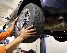 man installs a tire on a car in a body shop