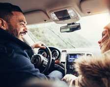 Man laughs at woman’s joke while driving