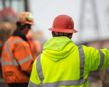 Construction workers stand at a distance