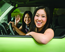 Two women smiling in green car