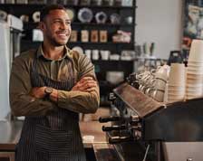 Coffee shop owner smiles behind counter