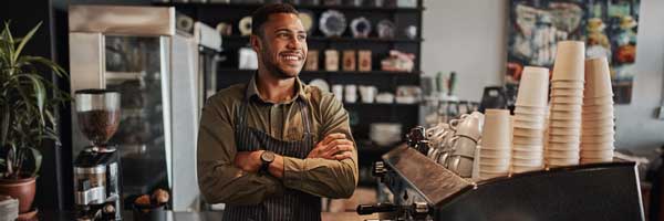 Coffee shop owner smiles behind counter