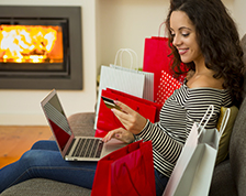 Woman shops for holiday gifts at home using her computer