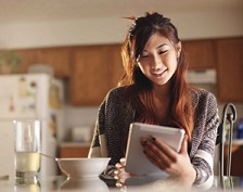 Woman uses tablet to create an inventory of the items in her kitchen