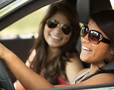 Two teenage girls chat while driving