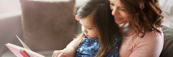 Woman and child read picture book together