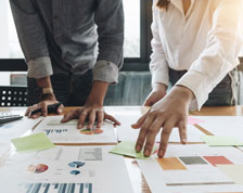 Two co-workers review business results during meeting