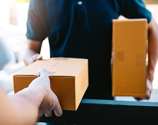 Delivery person hands a small package to an addressee.