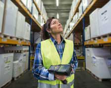 Woman holding scanner works in warehouse