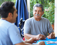 Man with mustache looks at grown son and smiles