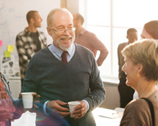 A diverse group of adults chat during a community meeting