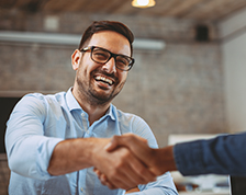 Two young men shake hands during a business meeting