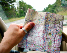 Man in driver’s seat holds up map