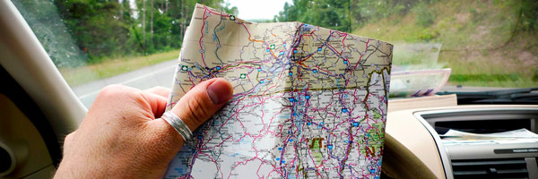 Man in driver’s seat holds up map