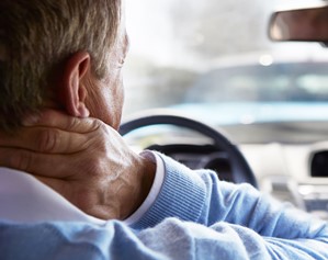 Man grabs the back of his neck after an auto accident