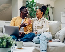 Couple relaxes on couch at home while having a conversation