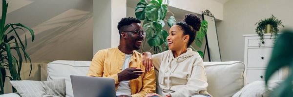 Couple relaxes on couch at home while having a conversation