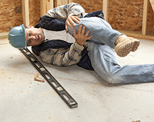 Construction worker holds his knee after falling