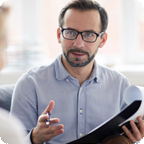 Insurance agent holds paperwork and explains a policy to a customer