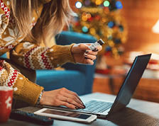 Woman shops for holiday gifts at home using her computer