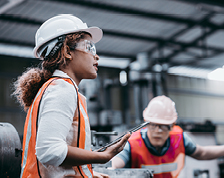 Woman and man in construction vests and hard hats