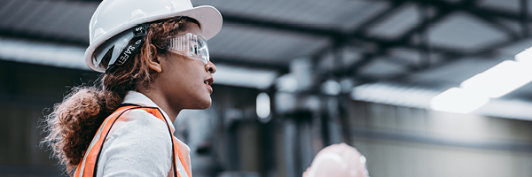 Woman and man in construction vests and hard hats