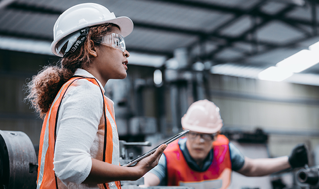 Woman and man in construction vests and hard hats